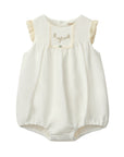 White baby romper with lace details on a white background