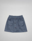 A slate blue corduroy mini skirt with an elastic waistband, button-front closure, and two decorative patch pockets, shown flat on a light gray background.