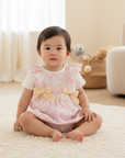 Asian baby girl in pink floral romper with white shirt seated in nursery