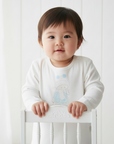 Asian baby in white bear graphic shirt without blue bow