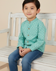 Asian boy in mint green shirt with blue jeans