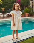 Asian girl in floral dress backyard pool Spanish tiles