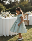 Asian girl in sage green smocked dress at special celebration