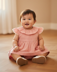 Baby Girl in Pink Dress - Seated on Wooden Floor