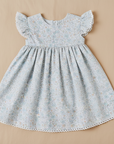 Blue floral dress flat lay beige background