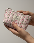Pink floral pouch in hands lifestyle photo