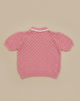 Pink knit polo sweater back view on beige background