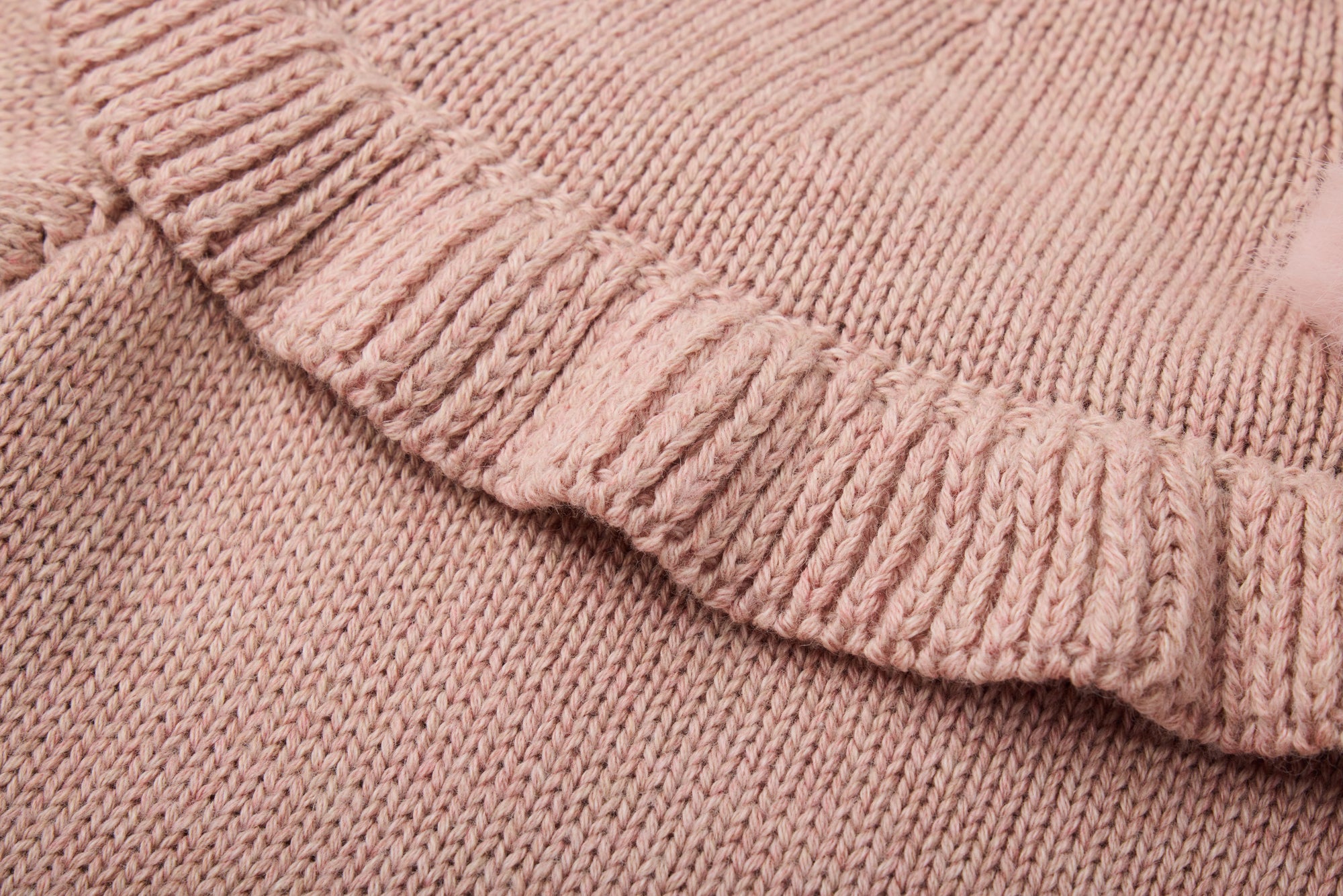 Pink knitted dress with a fluffy pink pom-pom.