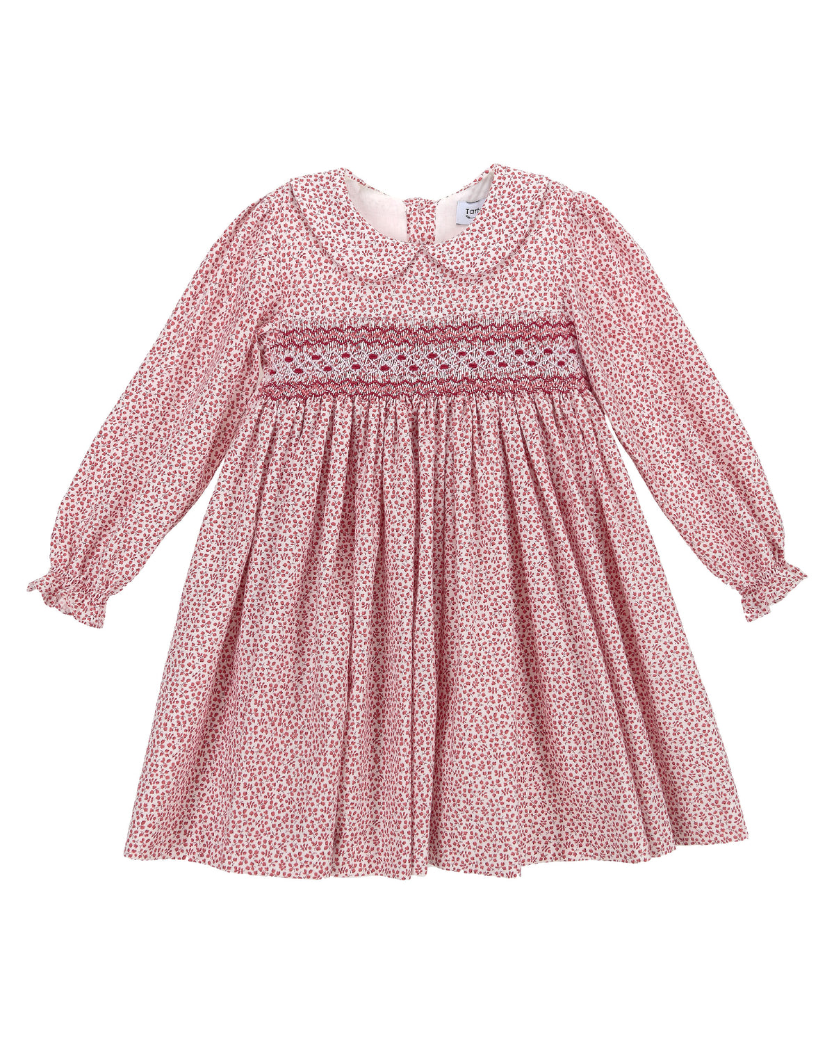 A pink and white patterned long-sleeve baby dress with a smocked chest band, laid flat against a white background.