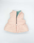 Reversible quilted vest in pink and green with ruffle.