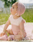 Girl's knitted romper with a pink knit body