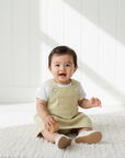 Asian baby girl in yellow stripe dungaree dress with white blouse