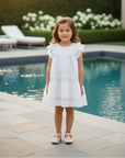 Asian girl in white dress with lace trim in backyard with pool