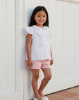Asian girl in white star blouse with pink shorts Spanish outdoor setting