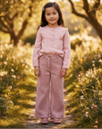 Asian little girl in pink blouse and corduroy pants outdoors