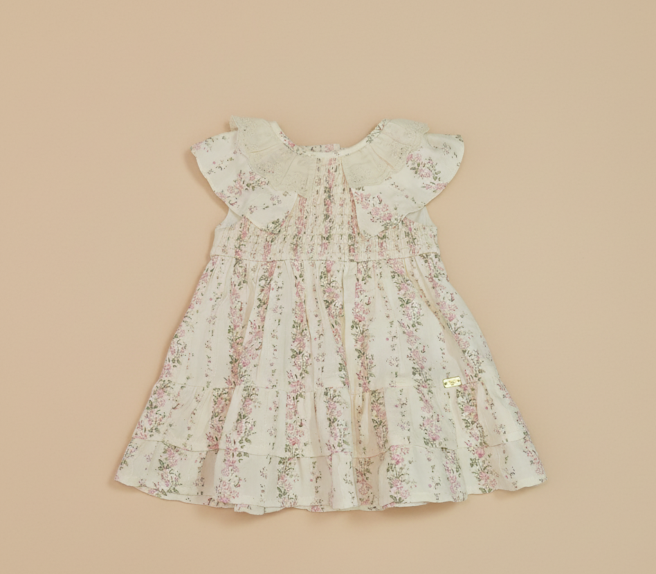 Cream floral baby dress on beige background