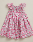 Front product photo of pink floral dress on beige background