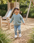 Girl in Sage Cardigan - Outdoor Play Area