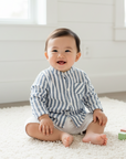 Lifestyle photo of Asian baby boy wearing navy gingham check shirt with unbuttoned collar and white shorts
