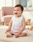 Lifestyle photo of Asian baby wearing pink romper seated on floor