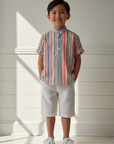 Lifestyle photo of Asian boy wearing colorful striped sailor collar shirt with white shorts and white sneakers