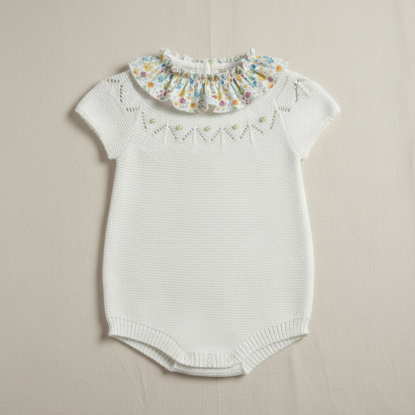 White knit romper with floral collar on beige background