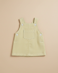 Yellow stripe seersucker dungaree dress flat lay beige background